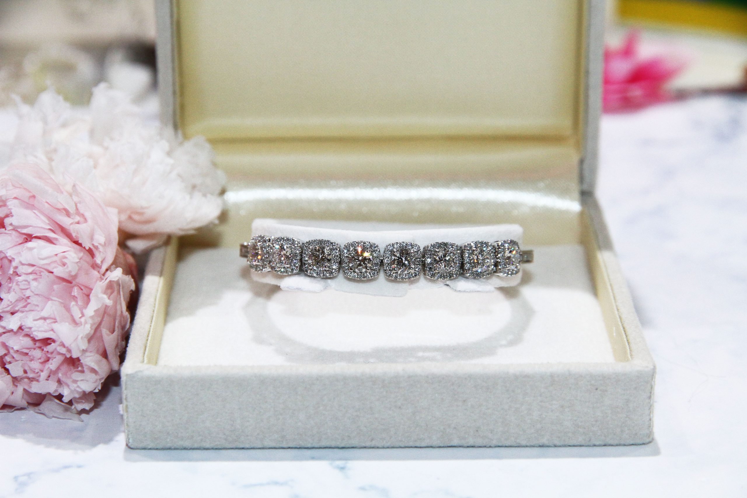 Halo tennis bracelet features centre diamonds surrounded by small diamonds